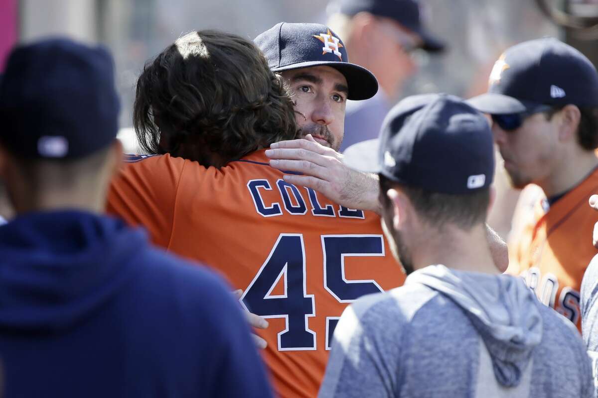 Houston Astros' Justin Verlander, center, hugs starting pitcher Gerrit Cole to congratulate Cole for a possible 20th win of the season, after the fifth inning of a baseball game against the Los Angeles Angels in Anaheim, Calif., Sunday, Sept. 29, 2019. (AP Photo/Alex Gallardo)