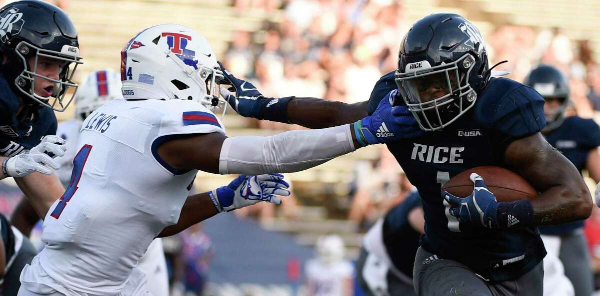 Rice running back Aston Walter, right, fends off Louisiana Tech safety Darryl Lewis en route to a touchdown during the first half of an NCAA college football game, Saturday, Sept. 28, 2019, in Houston.