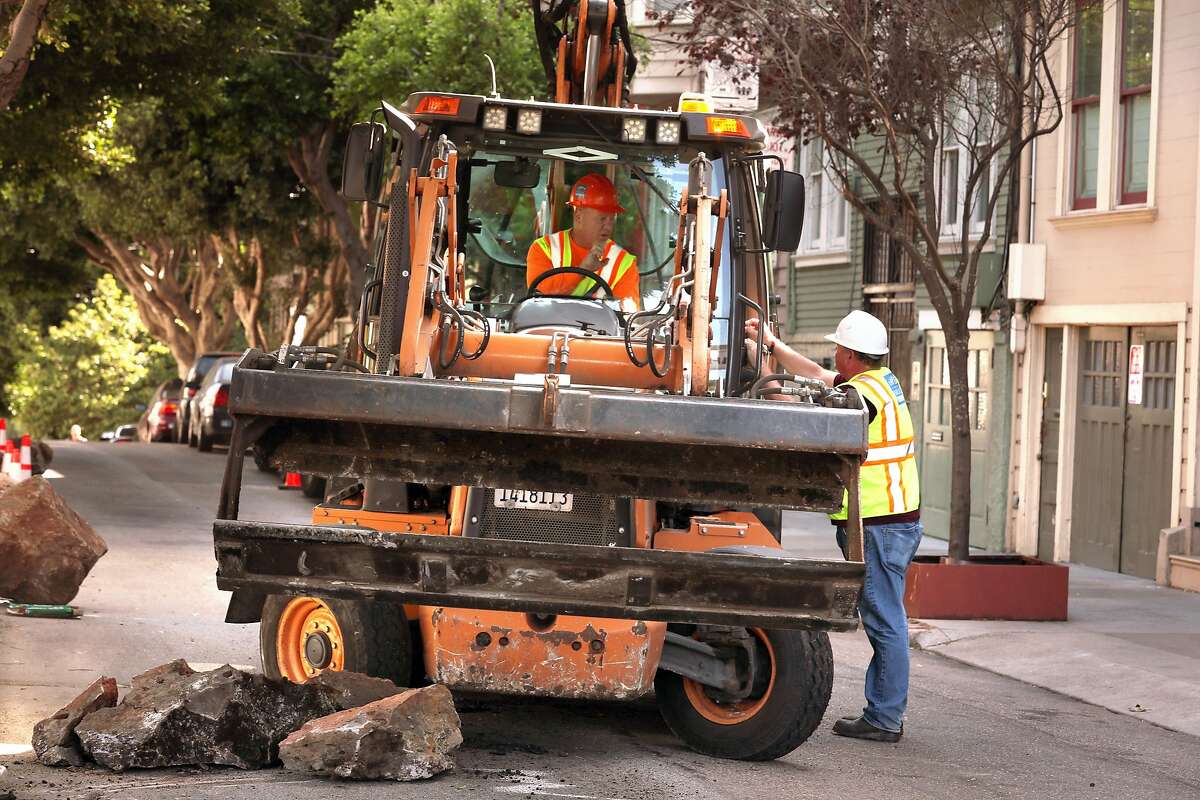 Public works removes boulders along the sidewalk along Clinton Park near Market at Dolores streets on Monday, Sept. 30, 2019, in San Francisco, Calif.