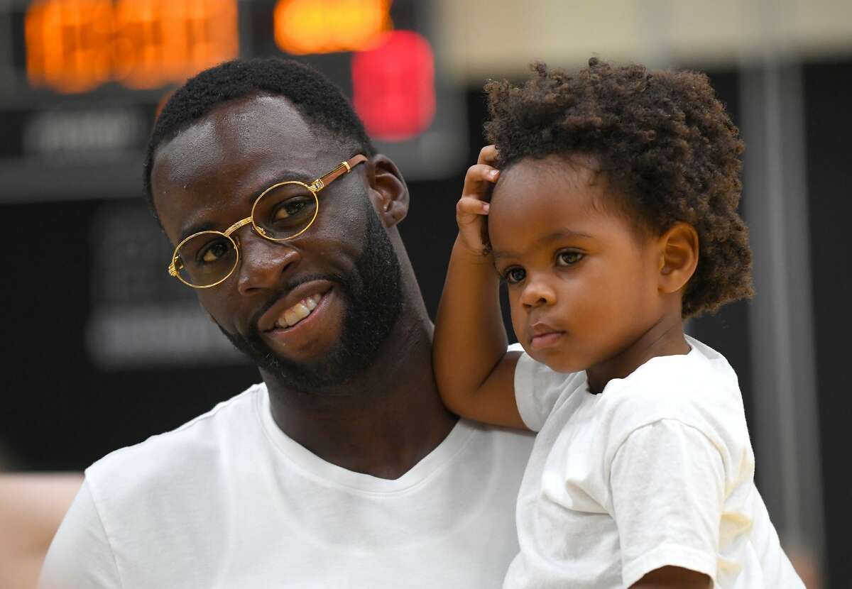 FILE - Draymond Green of the Golden State Warriors holds his son, Draymond Green Jr., on Aug. 15, 2019 in El Segundo, Calif. Draymond said Friday that he was a little disappointed in his kids' trick-or treating booty.