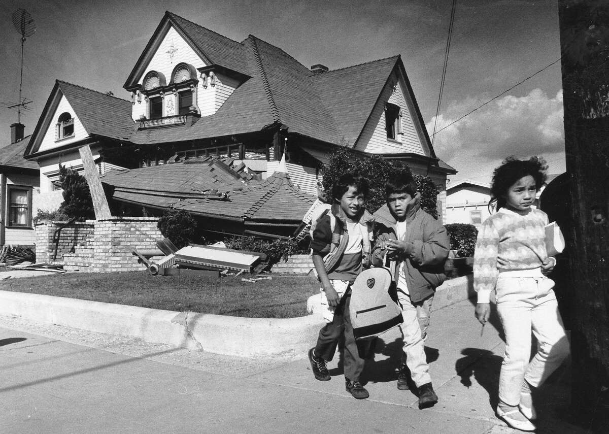 1989年10月26日，在沃特森维尔，孩子们走过被洛马普列塔地震破坏的第五和杰弗逊大道拐角处的一所房子