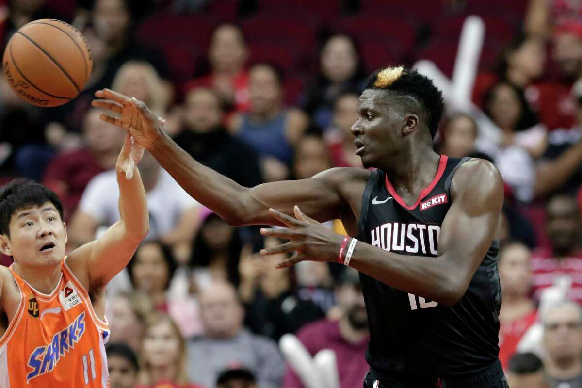 Houston Rockets center Clint Capela, right, passes the ball over Shanghai Sharks guard Shi Yuchen (11) during the second half of an NBA basketball preseason game Monday, Sept. 30, 2019, in Houston. (AP Photo/Michael Wyke)