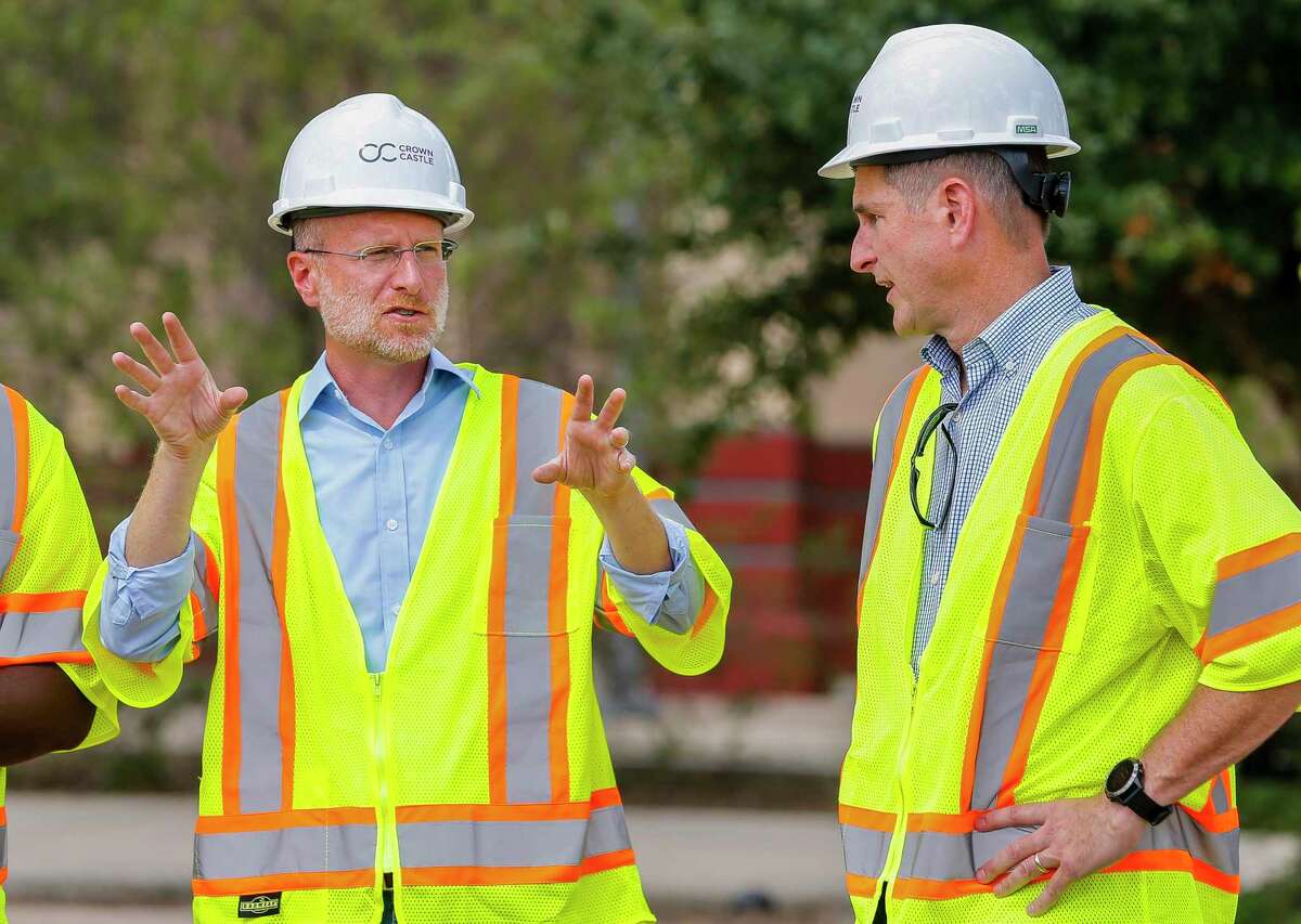 Brendan Carr (left), Commissioner of the Federal Communications Commission (FCC), speaks with Mike Kavanagh (right), Senior Vice President, Sales and Chief Commercial Officer of Crown Castle, at a site where work is underway to finish installing fiber that will one day support a 5G network, near Guadalupe Plaza Park in Houston's Second Ward, Monday, Sept. 30, 2019.