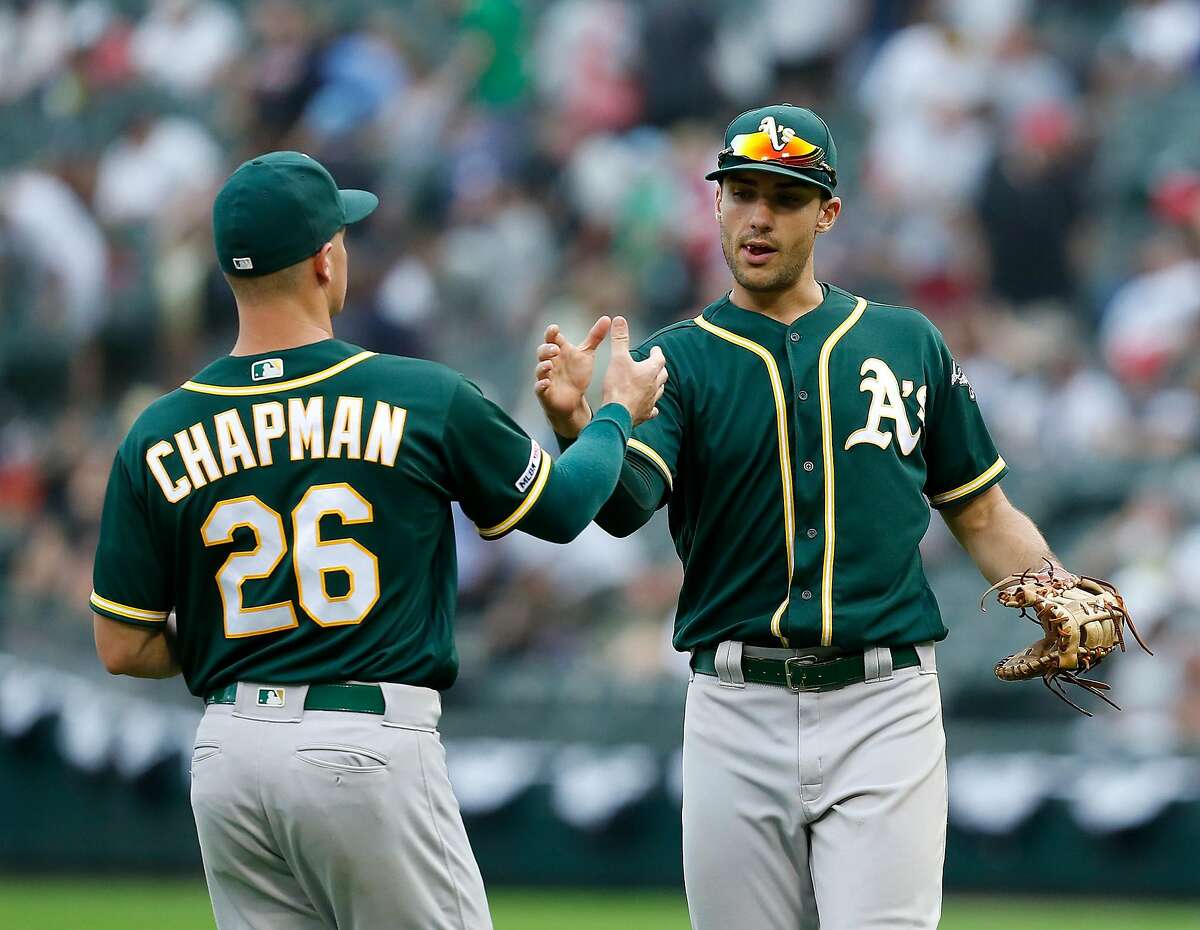 CHICAGO, ILLINOIS - AUGUST 11: Matt Chapman #26 of the Oakland Athletics congratulates Matt Olson #28 after their team's 2-0 win over the Chicago White Sox at Guaranteed Rate Field on August 11, 2019 in Chicago, Illinois. ~~