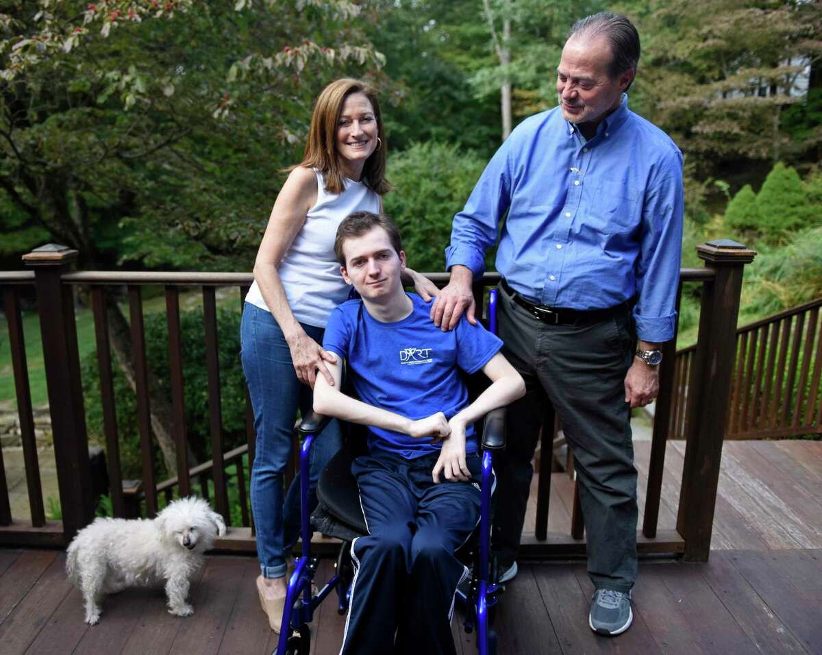 Phil and Andrea Marella with their son, Andrew, 20, and dog, Lacy, at their home in Greenwich. Andrew has a rare progressive genetic disorder called Niemann-Pick disease type C (NPC), which took the life of his sister, Dana, in 2013. The Marella's non-profit Dana?'s Angels Research Trust (DART) raises money to research the disease and is holding the DART to the Finish charity walk at Greenwich Point Park on Saturday, Oct. 5.