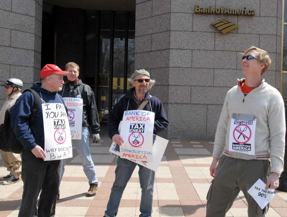 Protesters stand outside the Bank of America on Church Street in New Haven, October 7, 2013. They are protesting that the corporation should pay its taxes. L to r, Mark Colville, Stephen Kobasa and Dan Schweitzer.