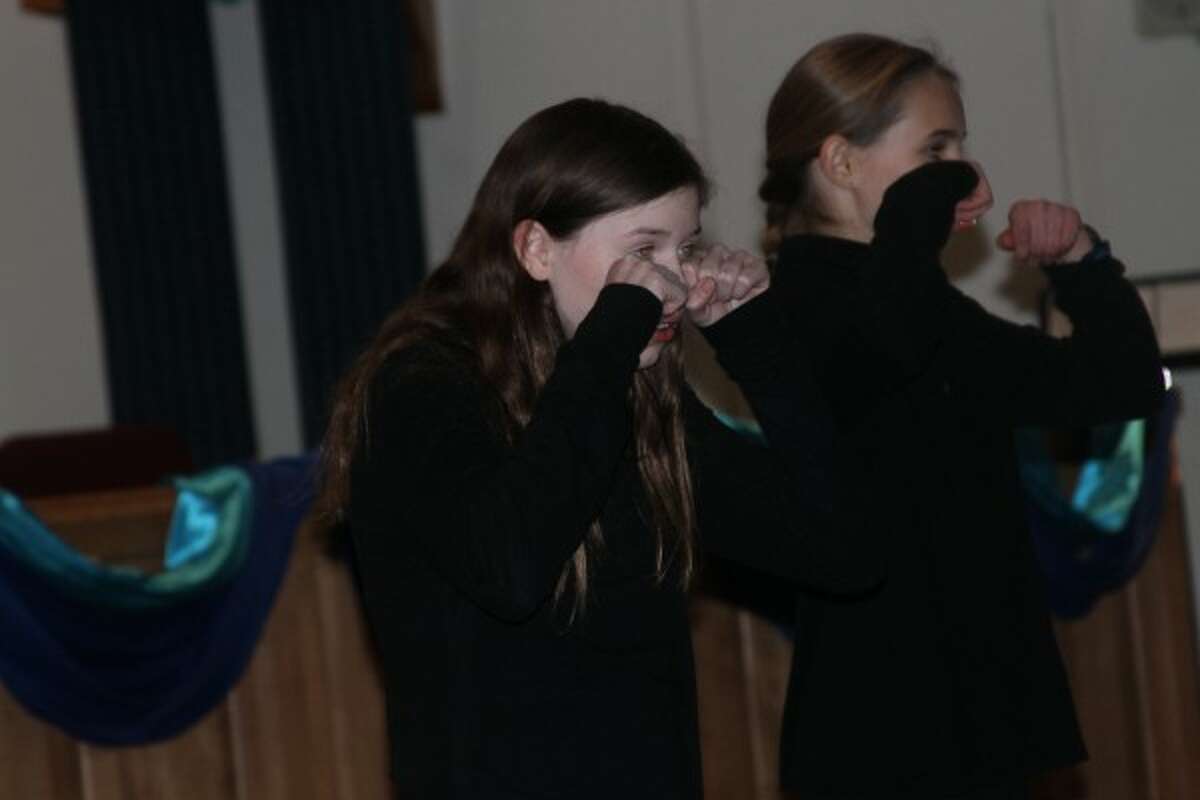 Olivia Holtgren, member of the Faith Covenant Church Children's Choir, pretends to cry during a singing skit at the community women's event at the church on Tuesday. (Justine McGuire/News Advocate)