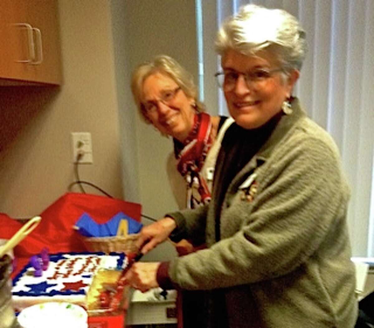 Manistee League of Women Voters president, Nancy Behring and treasurer Laurie Mason serve up the 95th anniversary cake to league members on Thursday. (Courtesy photo)