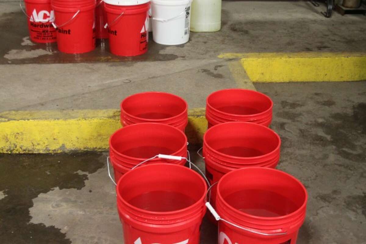 Red buckets were brought along with those distributing water in case someone they were helping needed to flush a toilet. (Sean Bradley/News Advocate)