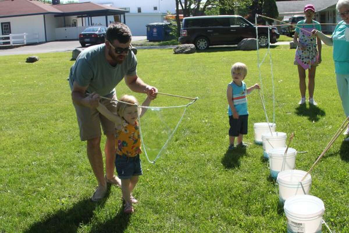 Matt Hanson helps his daughter Lennon Hansen make a bubble on Saturday during Family Fun Day at Onekama Village Park. (Michelle Graves/News Advocate) ***CLICK THROUGH FOR MORE PHOTOS***