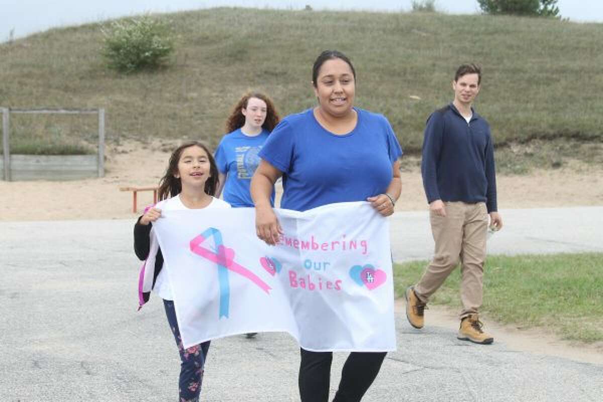 The 2016 Walk to Remember Saturday at Manistee Catholic Central had about 35 people walking in honor of lost infants due to stillbirth, miscarriage or early infant death. Ava (left) and her mother Angelina Anderson carried a banner throughout the walk which read "Remember Our Babies." (Sean Bradley/News Advocate)
