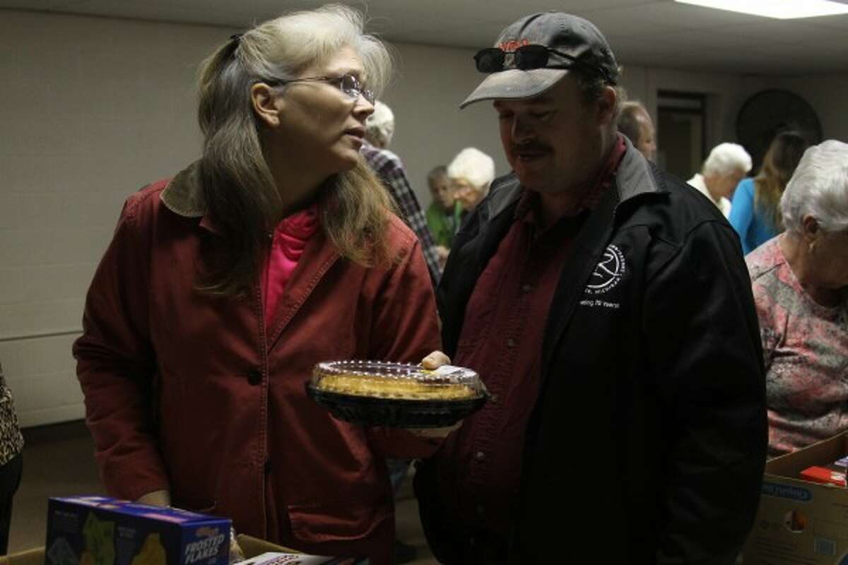 Manistee residents Elizabeth and Steven Mellott debate about taking a pie Friday from the Matthew 25:35 Food Pantry in Manistee. "God opened this door so we could eat," Elizabeth Mellott said. "This is our one way to be able to afford to eat because the food (cost) in regular stores is so astronomically outrageous." (Sean Bradley/News Advocate)