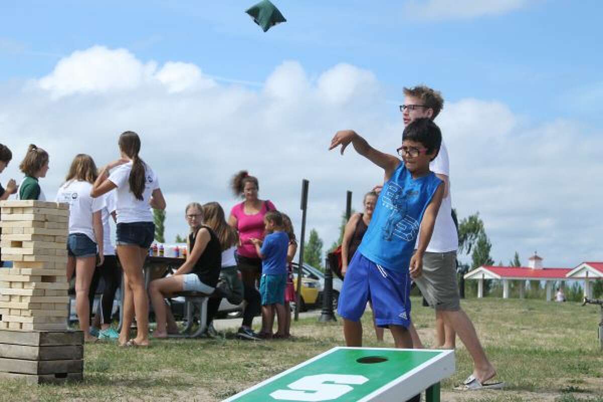 Vincent Leon, 8, plays cornhole at the United Way community picnic on Wednesday afternoon. (Dylan Savela/News Advocate)