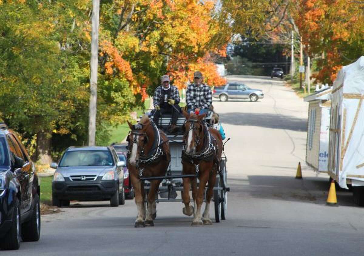 Families were able to take a wagon ride through Onekama during the Fall Festival. (Ashlyn Korienek/News Advocate)