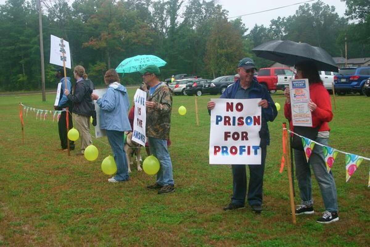 Lake County Democratic Party members join the protest against the opening of North Lake Correctional facility on Tuesday, Oct. 1 in Baldwin. Despite the weather, protesters hung around to show their opposition to the facility. (Star photo/Cathie Crew)