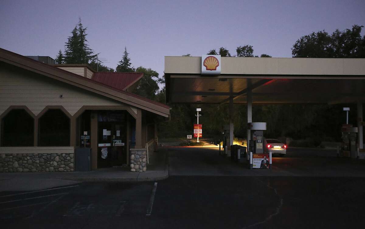 In this Wednesday morning, Sept. 24, 2019 photo, a gas station in Penn Valley, Calif. sits dark as motorists check to see if the pumps were working. Pacific Gas & Electric has shut off power to 24,000 customers in the Sierra Nevada foothills and says it will remain off until dangerous wildfire weather eases. (Elias Funez/The Union via AP)