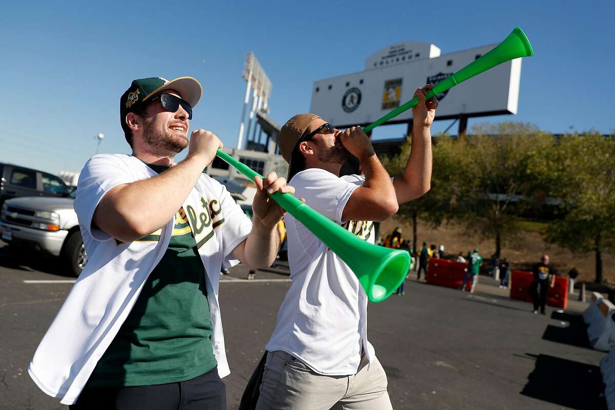 Brothers and Oakland Athletics' fans, Dylan and Evan Dreyer of Sacramento blow horns before Oakland Athletics play Tampa Bay Rays in American League Wild Card game at Oakland Coliseum in Oakland, Calif., on Wednesday, October 2, 2019.