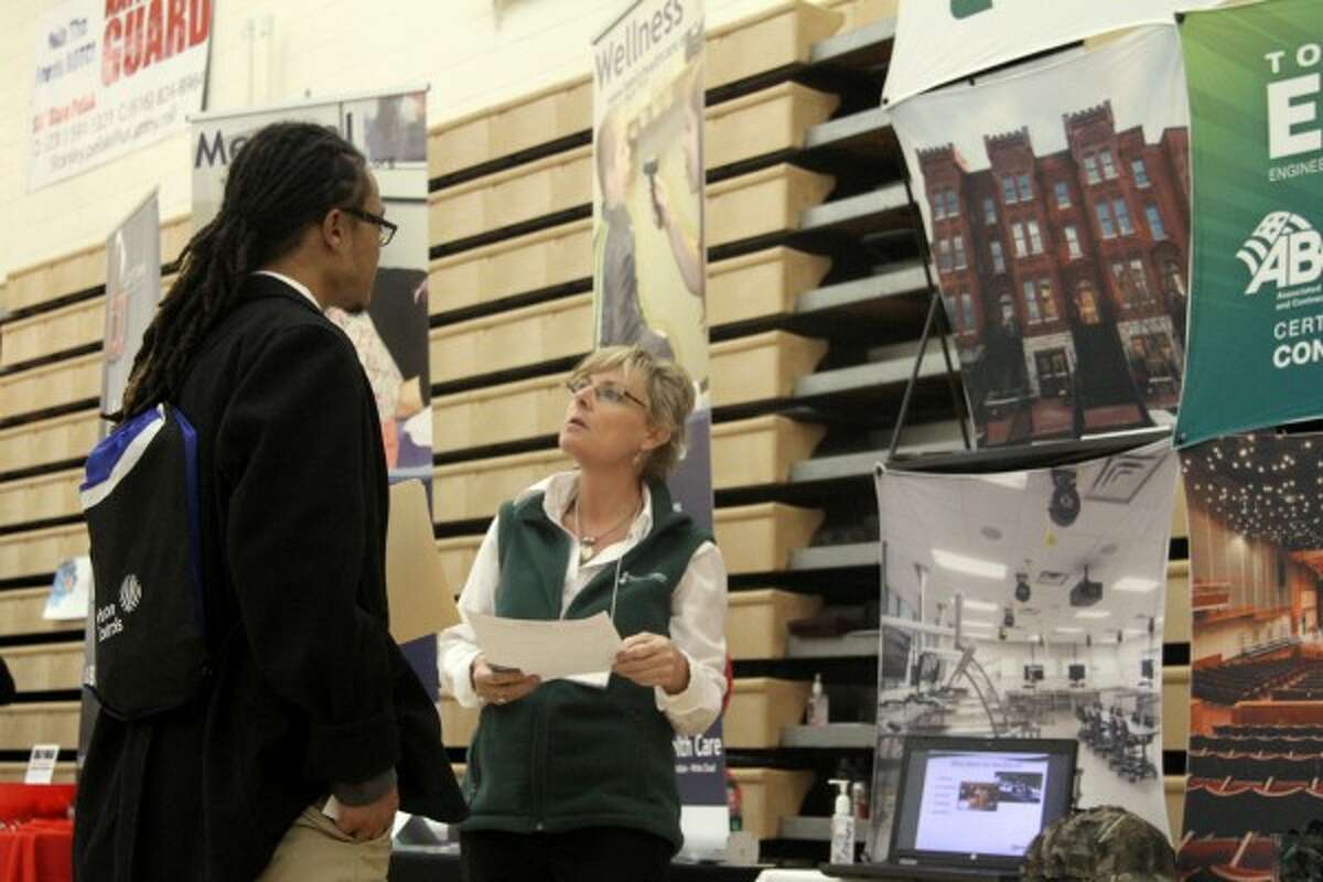JOB HUNT: Cindy Tomlinson, human resources manager at Rockford Construction, reviews a resume from HVAC major Mark English during Thursday's Career and Internship Fair at Wink Arena. (Pioneer photos/Whitney Gronski-Buffa)