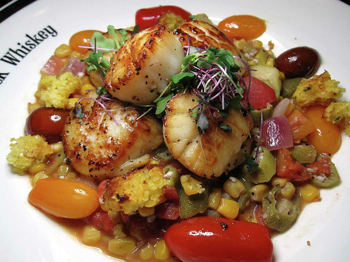 Sea scallops come with grilled corn, okra succotash, tomatoes and cornbread at Maverick Whiskey.