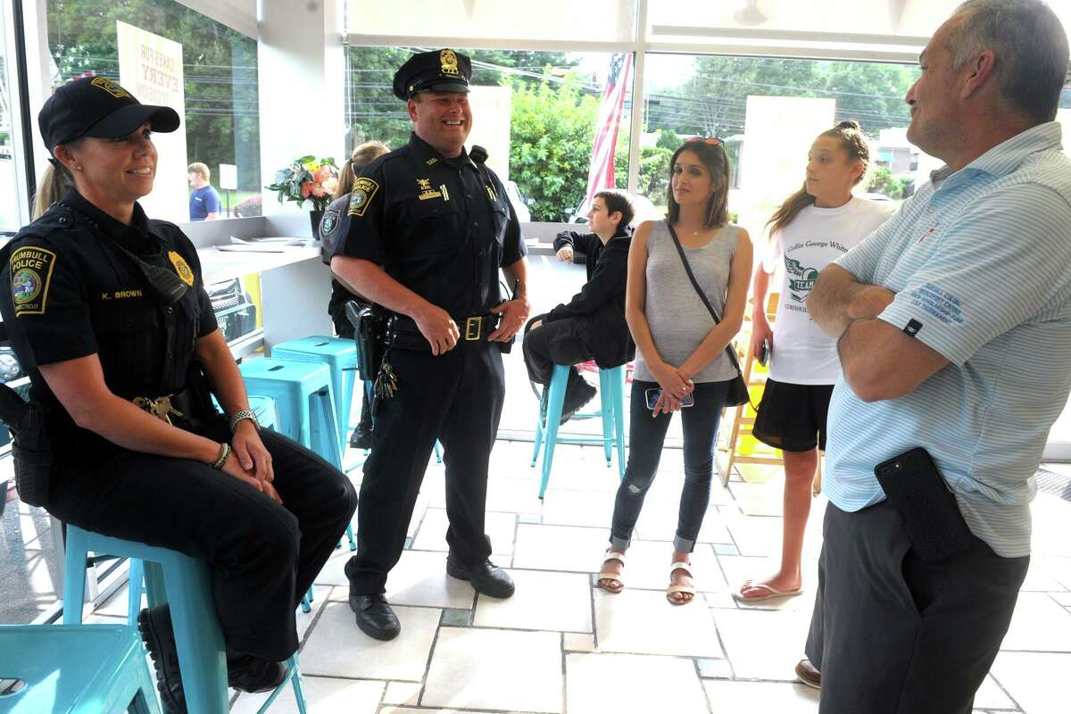 Members of the Trumbull Police Department, including Chief Michael Lombardo, right, visited Sunny Daes ice cream shop during the Cops and Cones event in Trumbull, Conn. Aug. 16, 2019.