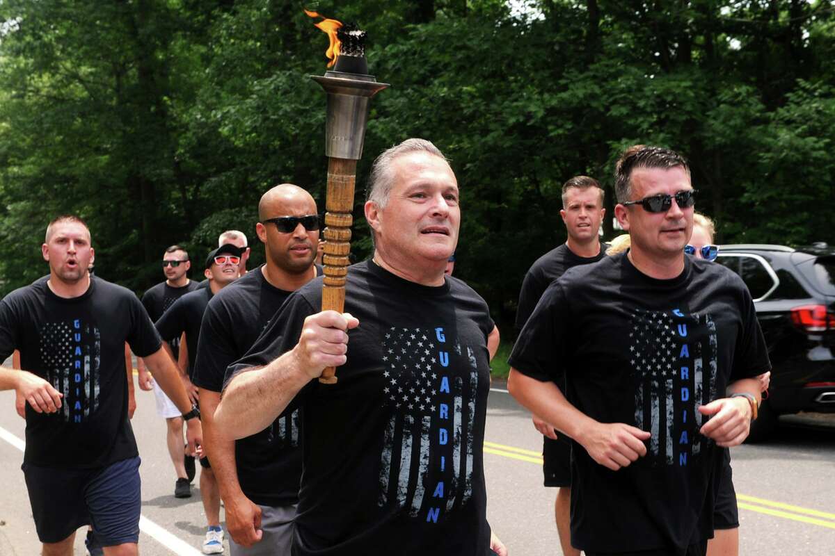 Trumbull Police Chief Michael Lombardo carries the torch in the Law Enforcement Torch Run for Special Olympics, seen here in Trumbull, Conn. June 8, 2018. The three-day run by police officers covered several routes through over 100 cities and towns in the state, and culminated at the opening ceremonies Friday for Connecticut Special Olympics, which take place this weekend at Southern Connecticut State University.