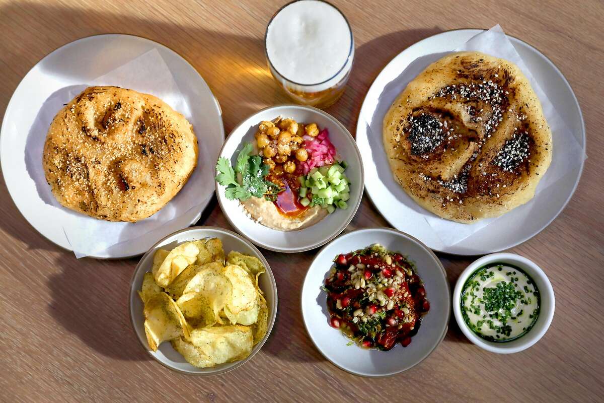 Party Bread (top left and right) with Early Girl Tomato curry (bottom middle) and Sichuan Hummus (top middle) with Park beer by Fort Point Beer Co. seen on Tuesday, Oct. 1, 2019, in San Francisco, Calif. Fort Point Beer Co., San Francisco's largest independent brewery, opens a 3,000-square-foot beer hall on Oct. 7.