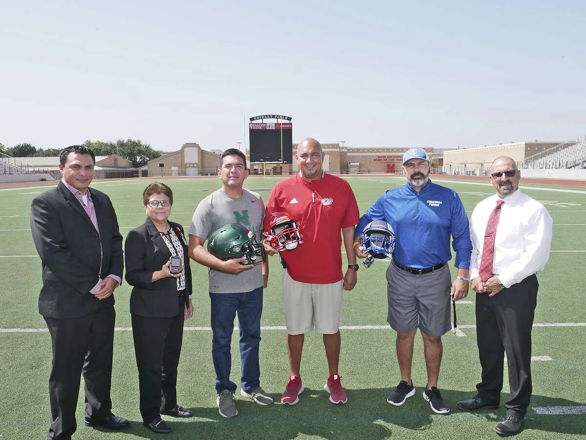 Laredo ISD Athletics Department Director Sylvia barrera and her assistants Luis Escamilla, left and Tommy Ramirez, right, are photographed with Antonio Villalon, head football coach at Nixon, David Charles, head football coach at Martin and Carlo Hein, head football coach at Cigarroa, as they show the Riddell Smart Helmet technology aquired by LISD for football programs in the district.