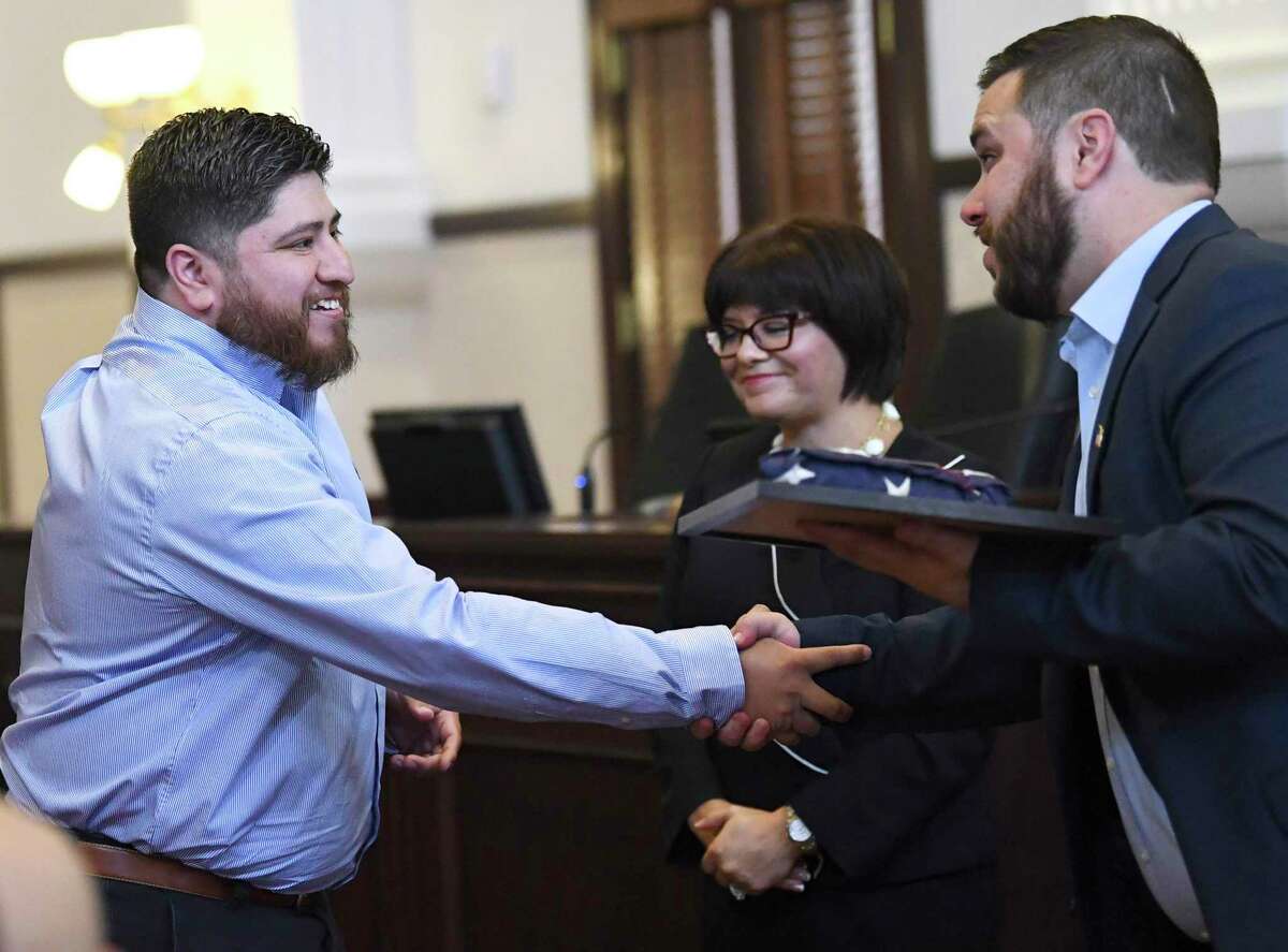 Army veteran Daniel Segundo, left, a graduate of the first Felony Veterans Treatment Court, shakes hands with John Herman, who hands him a flag and certificate, at the Bexar County Courthouse on Thursday, Oct. 3, 2019. The program assists military veterans who have been charged with felony offenses.