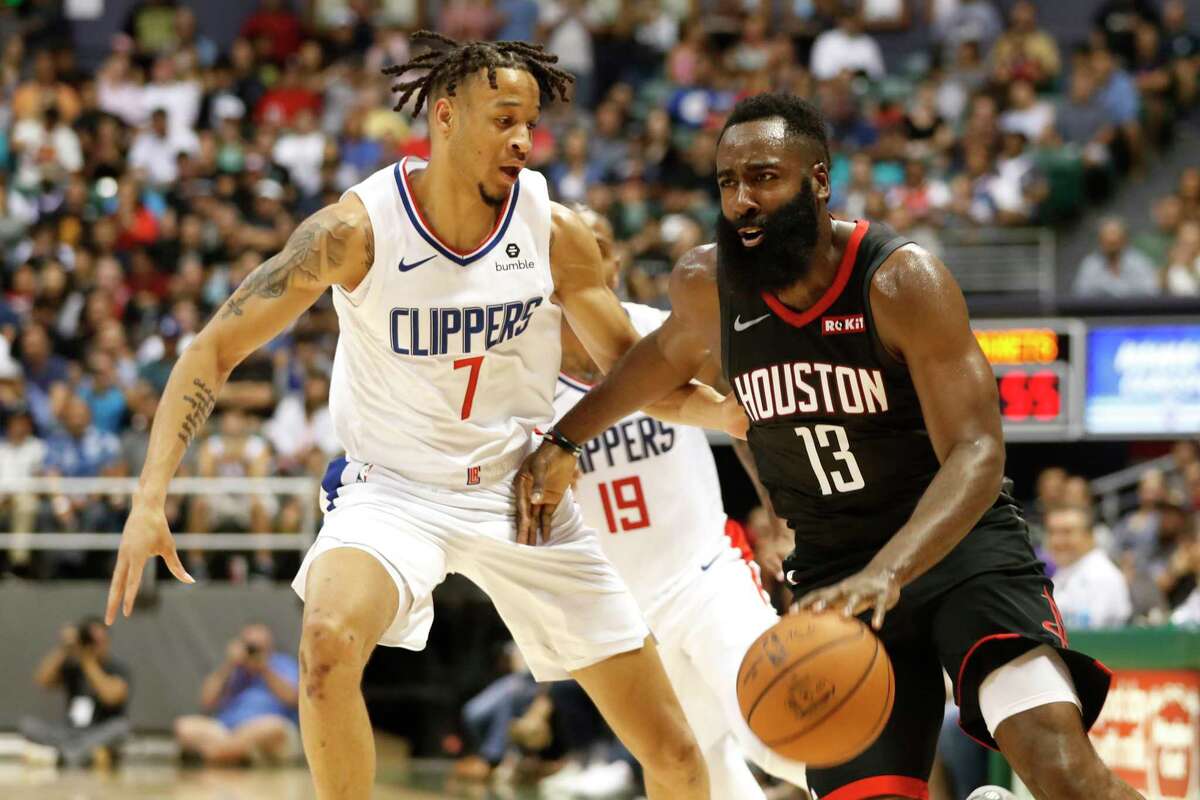 Los Angeles Clippers shooting guard Amir Coffey (7) guards Houston Rockets shooting guard James Harden (13) during the second quarter of an NBA preseason basketball game, Thursday, Oct 3, 2019, in Honolulu.