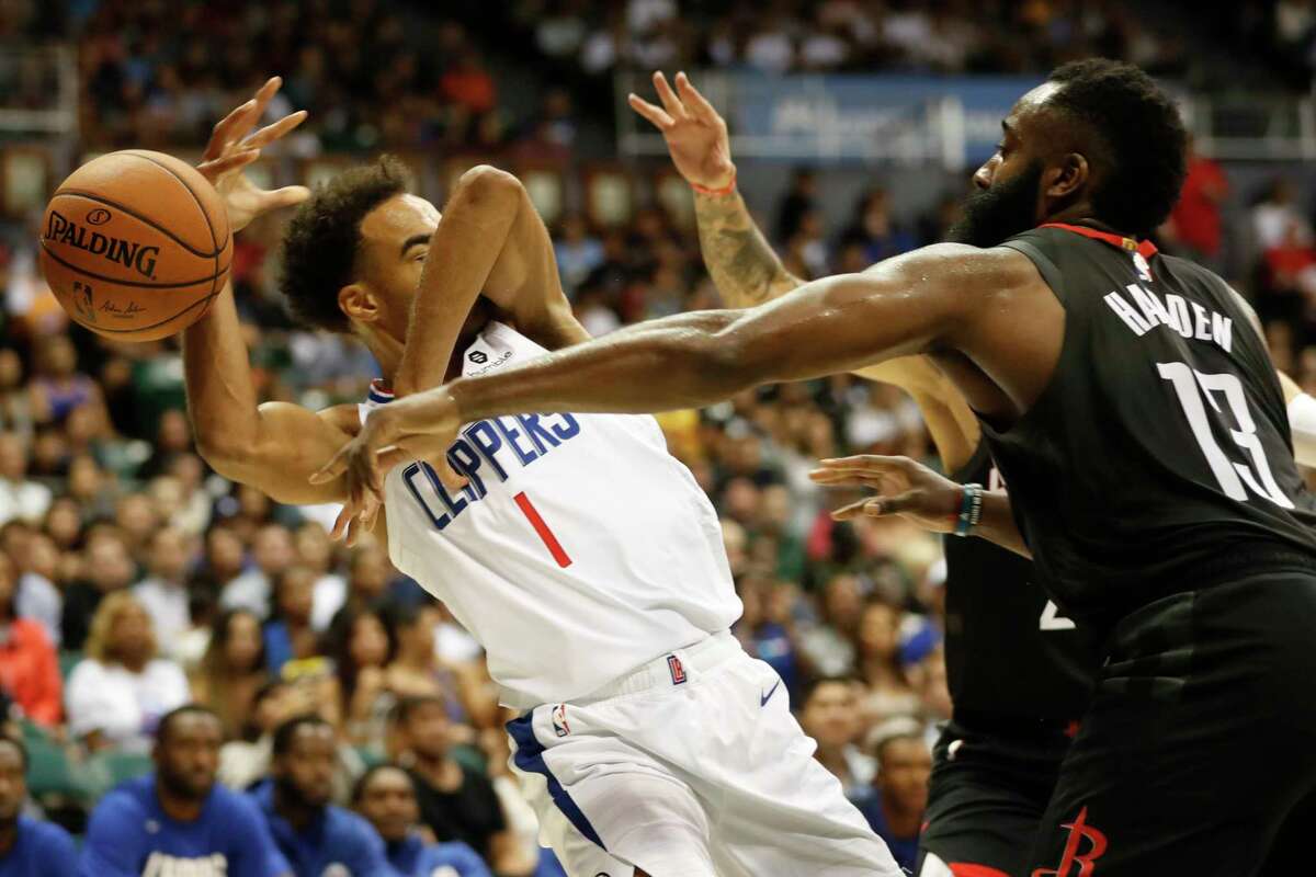 Houston Rockets shooting guard James Harden (13), knocks the ball away from Los Angeles Clippers shooting guard Jerome Robinson (1) during the third quarter of an NBA preseason basketball game against the Los Angeles Clippers, Thursday, Oct 3, 2019, in Honolulu. (AP Photo/Marco Garcia)