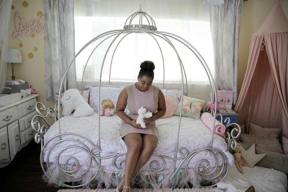 Ajshay James sits on her daughter's bed in July. The stuffed lamb she is holding is bigger than Harper was as a newborn. Photo: Elizabeth Conley/Staff Photographer