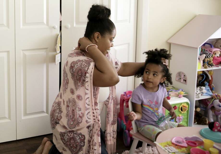 Ajshay James fixes her daughter's hair during one of her scheduled visits. Photo: Elizabeth Conley/Staff Photographer