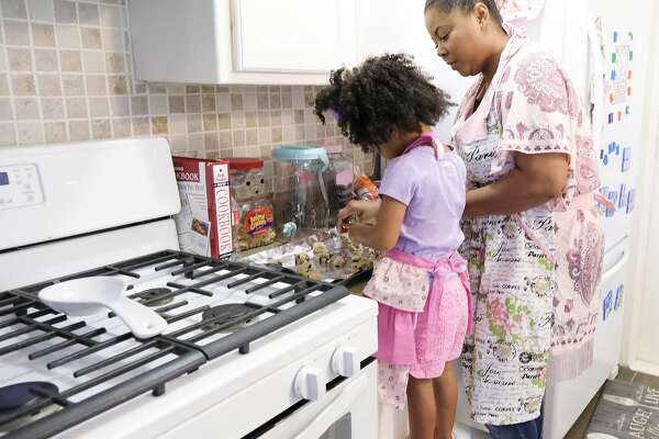 Ajshay James and her daughter, Harper, make cookies during a visit.