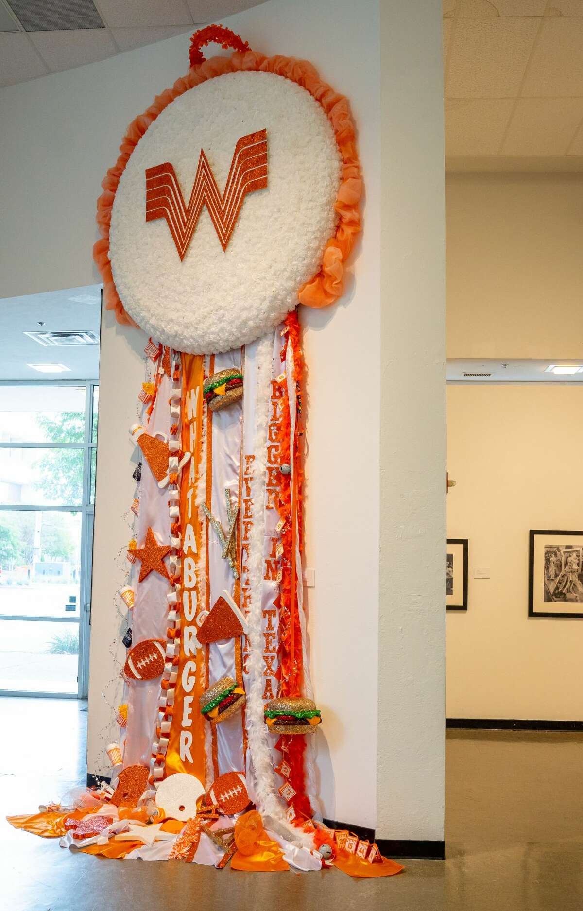 Clocking in at 18 feet tall and six feet wide, the massive mum took 120 hours to build and was constructed with 1,250 flower heads, 50 Whataburger drink cups, 100 fry containers, 300 feet or ribbon, 80 bracelets and key chains and 165 feet of feathered fringe.