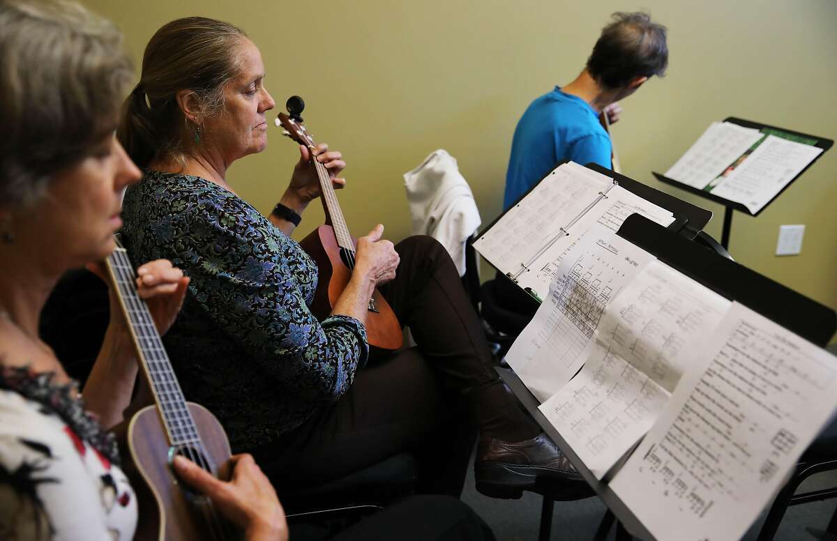 Students Lori Tannyhill, left, Anne Bengtson, and Vicky Thomas strum their instruments as Hiram Bell teaches a Beginning Ukulele class at Freight and Salvage in Berkeley, Calif., on Thursday, October 3, 2019. Freight and Salvage offers dozens of classes a year on traditional music. They are reclassifying all the instructors as employees because of California's new gig work law, AB5.
