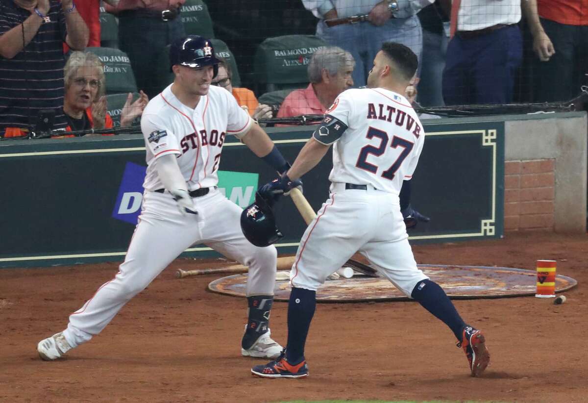 Houston Astros second baseman Jose Altuve (27) celebrates his two-run home run with Alex Bregman (2) in the first game of the ALDS against Tampa Bay Rays at Minute Maid Park on Friday, Oct. 4, 2019.