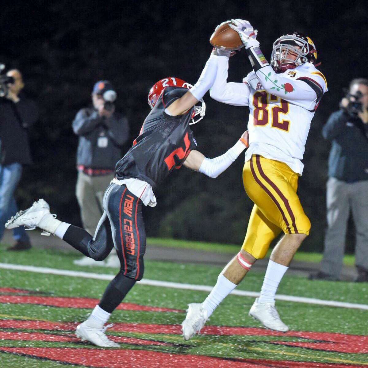 St. Joseph’s Will Diamantis catches a touchdown pass from Jack Wallace with New Canaan’s Dean Ciancio defending during the Cadets’ 58-14 victory on Friday at Dunning Field in New Canaan.
