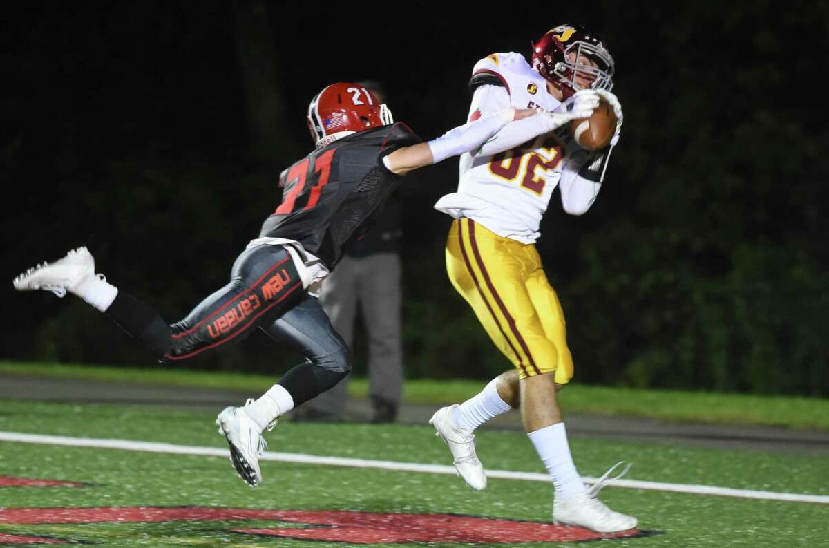 St. Joseph’s Will Diamantis (82) catches a touchdown pass from QB Jack Wallace with New Canaan’s Dean Ciancio (21) defending during a football game at Dunning Field on Friday, Oct. 4, 2019.