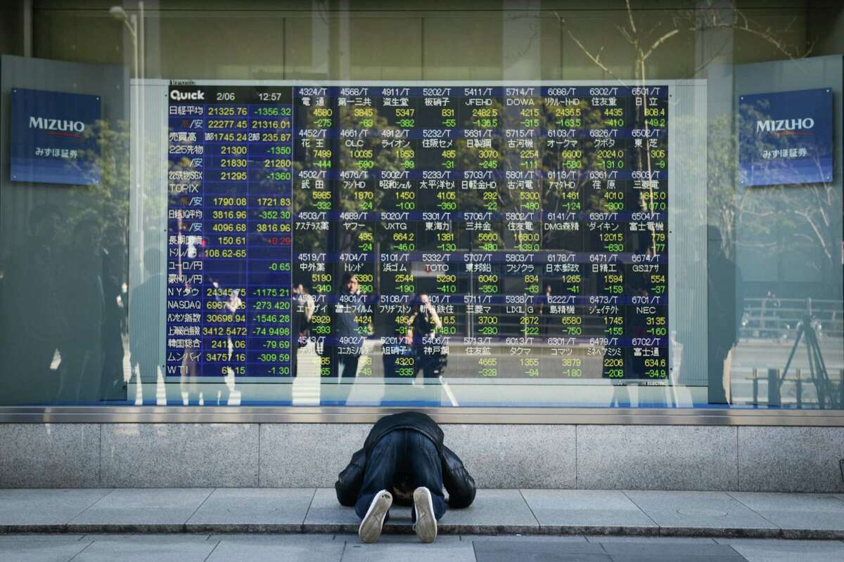 A man looks at an electronic stock board showing a chart of the Nikkei Stock Average outside a securities firm in Tokyo on Feb. 2, 2018.