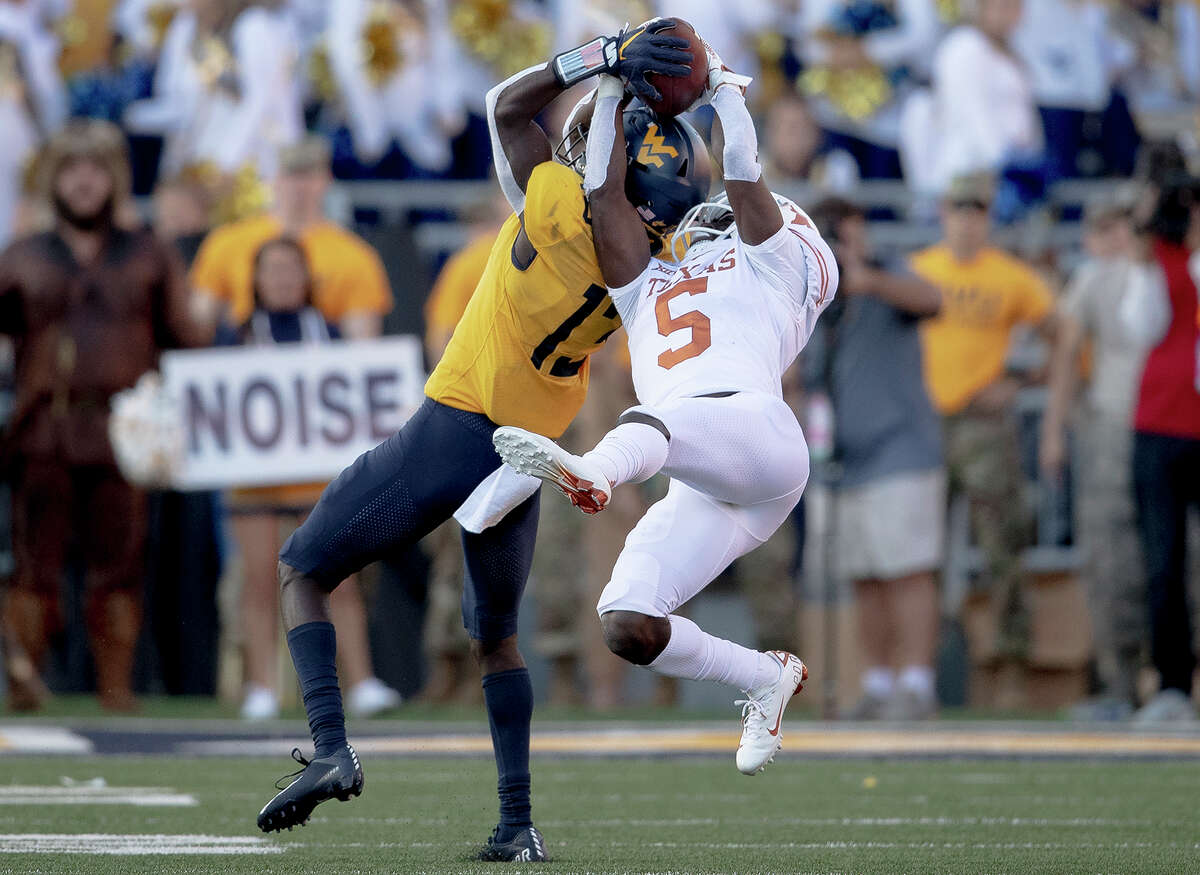 Texas defensive back D'Shawn Jamison (5) intercepts a pass intended for West Virginia wide receiver Sam James (13) during an NCAA college football game on Saturday, Oct. 5, 2019, in Morgantown, W.Va. (Nick Wagner/Austin American-Statesman via AP)