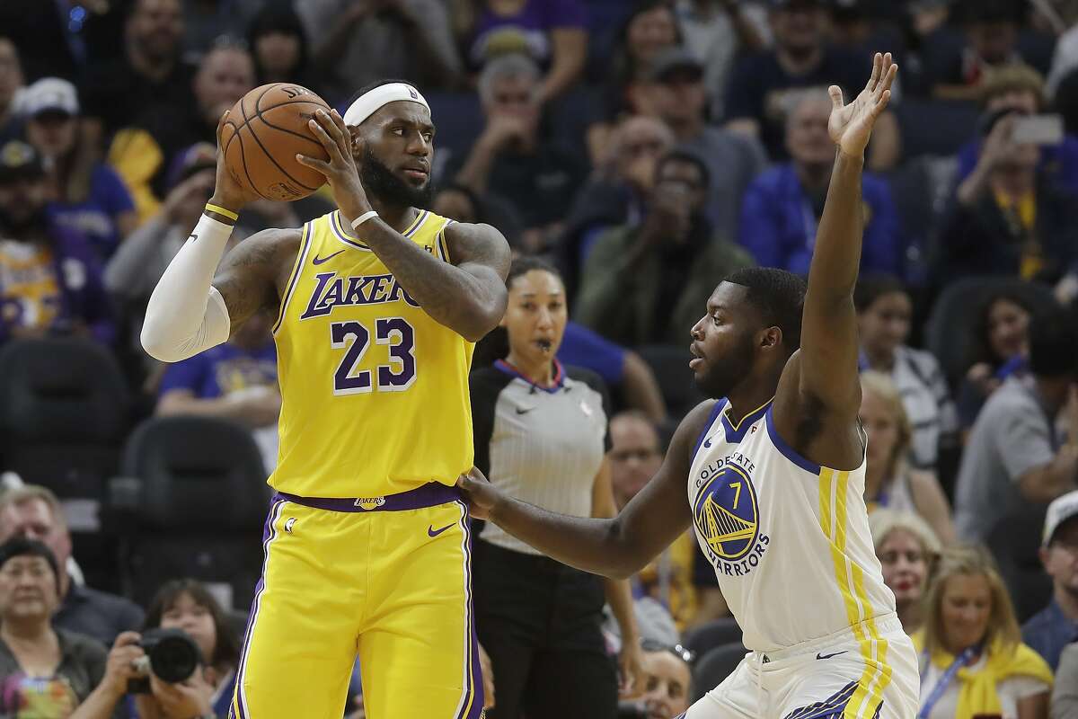 Los Angeles Lakers forward LeBron James (23) is defended by Golden State Warriors forward Eric Paschall (7) during the first half of a preseason NBA basketball game in San Francisco, Saturday, Oct. 5, 2019. (AP Photo/Jeff Chiu)