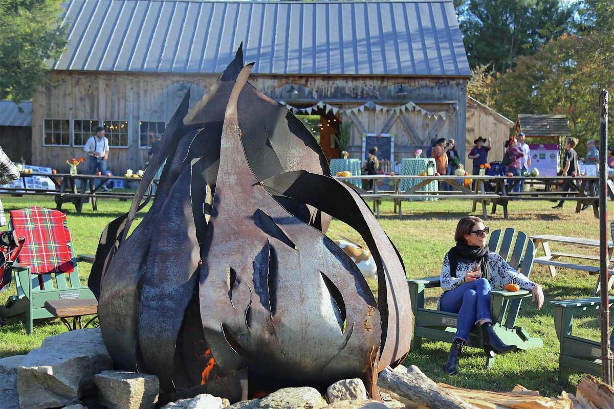 Holly Arcadi of Westport relaxes by the bonfire at the Lachat Town Farm annual Hoedown Barn Dance & BBQ on Saturday, Oct. 5, 2019, in Weston, Conn.