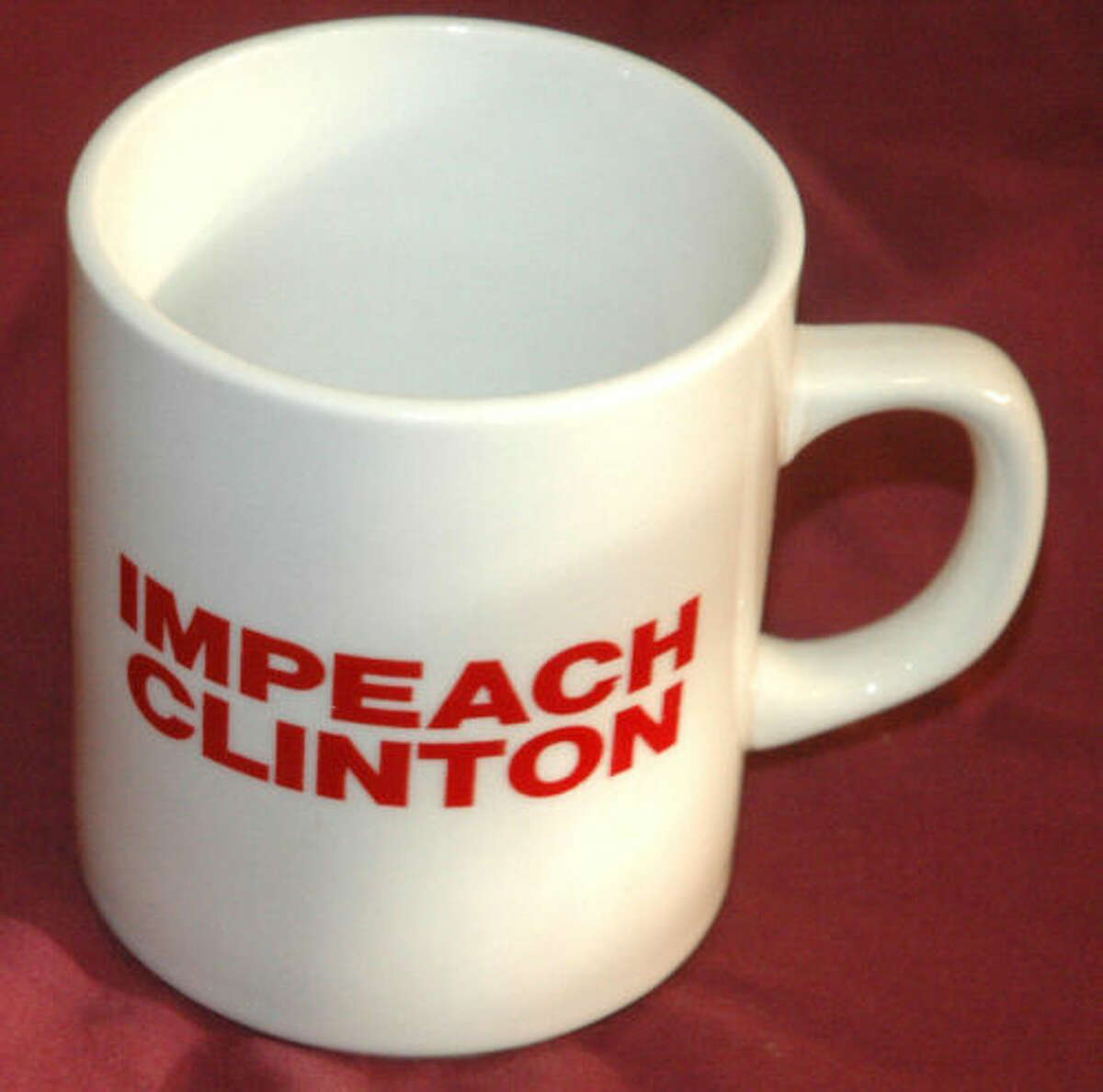 It's simple: it's a mug, it holds liquids, and it advertises the Clinton impeachment. Vintage 1990s mug.