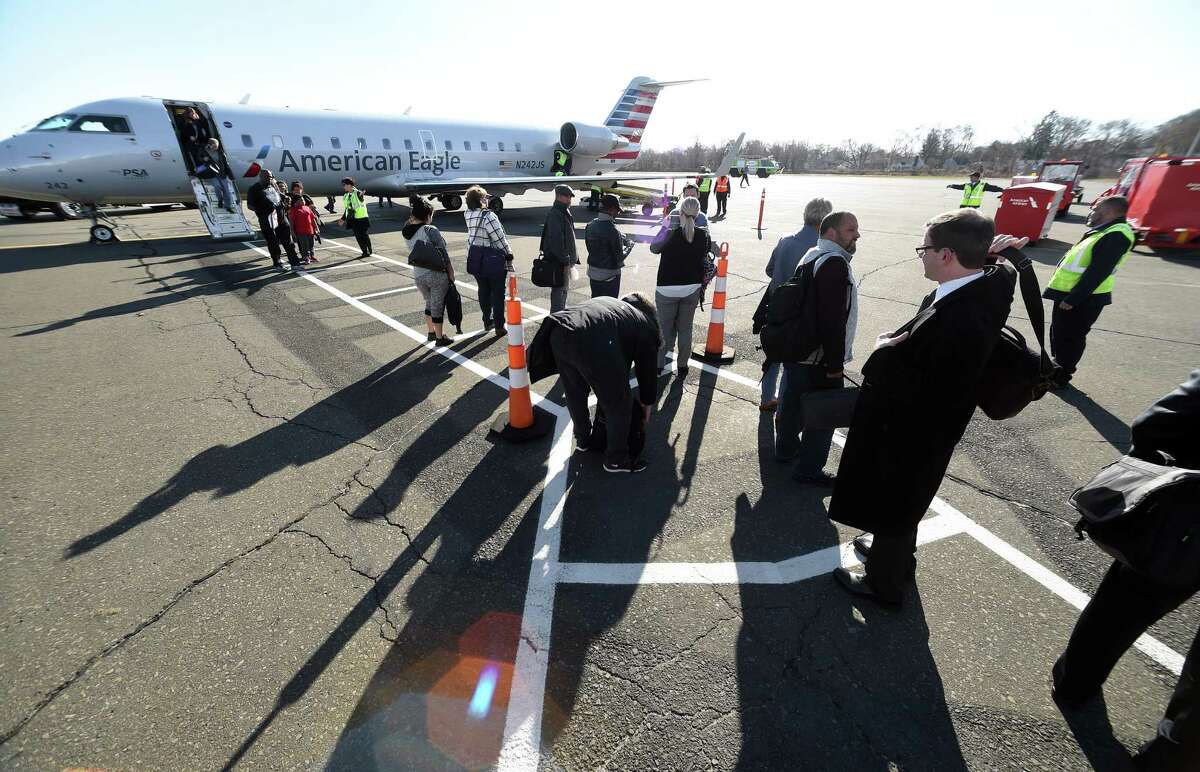 Passengers disembark the first American Eagle Canadair RJ 200 regional jet originating in Philadelphia and landing at Tweed New Haven Airport in New Haven on November 29, 2017.