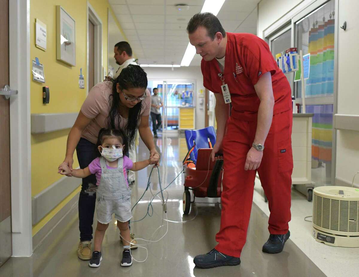 Addison Gonzalez is helped by her mother, Lilian Garcia, at University Hospital, where she is being treated after falling into a septic tank in Harlingen. Addison was exposed to the toxic gas hydrogen sulfide, prompting the use of an ECMO machine to support her heart and lungs. Casey Howard, director of the ECMO department at University Hospital, walks with Addison on Friday, Oct. 4, 2019.