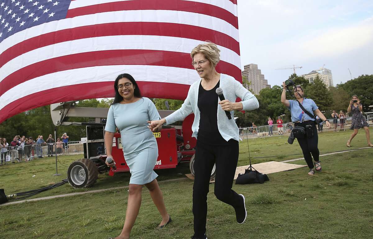 Presidential candidate Elizabeth Warren runs onto the stage with Jessica Cisneros as she holds a town hall meeting at Vic Mathias Shores at Lady Bird Lake Metro Park on September 10, 2019.