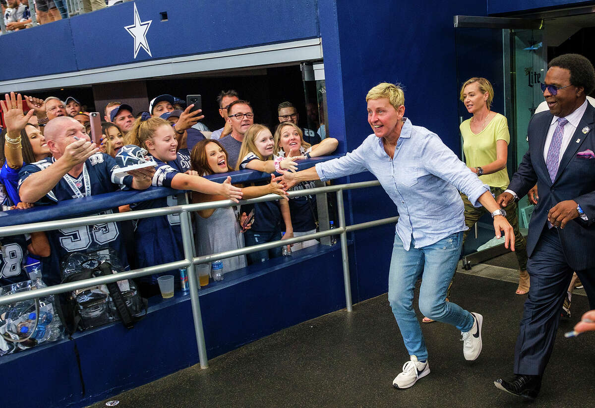 Ellen DeGeneres high-fives fans before an NFL football game between the Dallas Cowboys and the Green Bay Packers on Sunday at AT&T Stadium.
