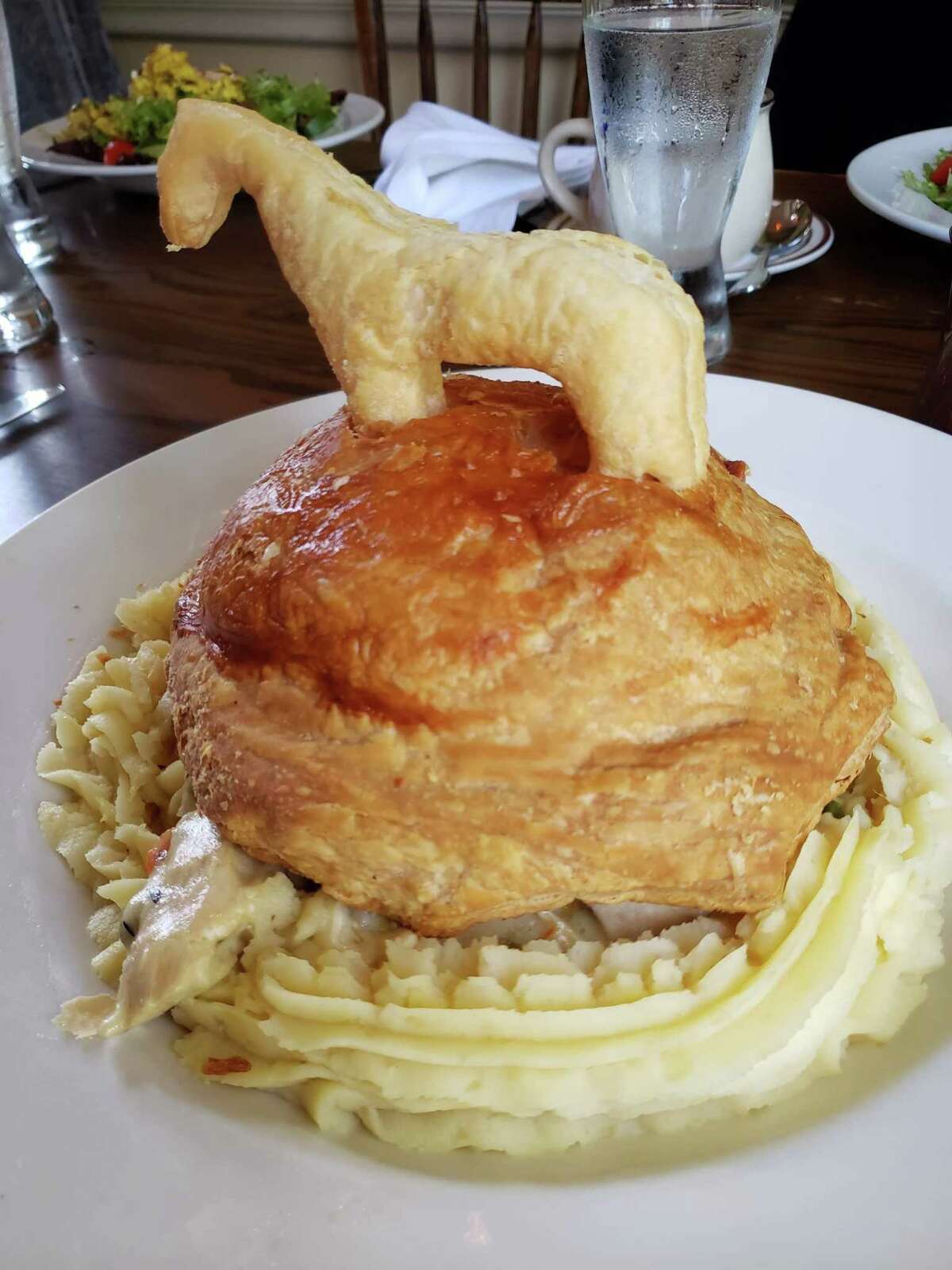 A pastry horse stands astride a pasture of puff pastry atop the hearty chicken pot pie.