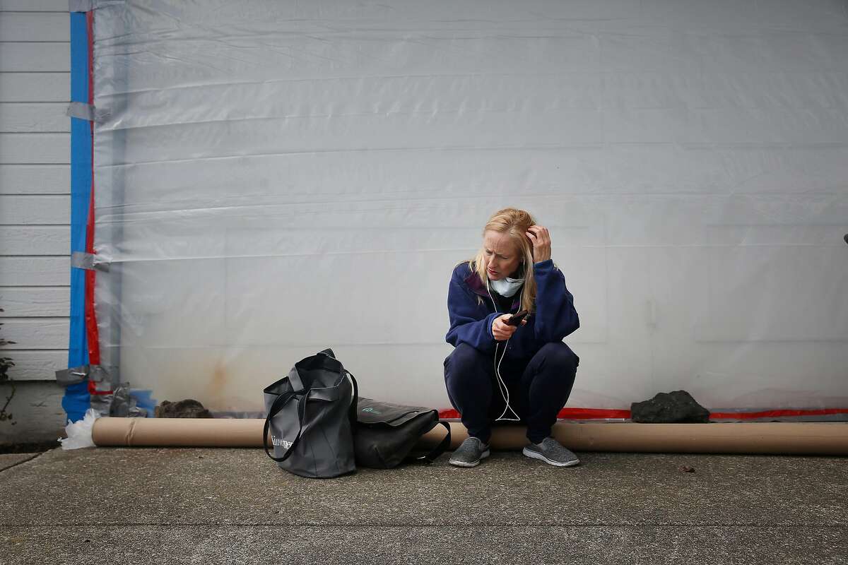 Lisa Mast makes phone calls for appointments as she sits in front of the garage outside her standing home on Friday, March 16, 2018, in Santa Rosa, Calif.