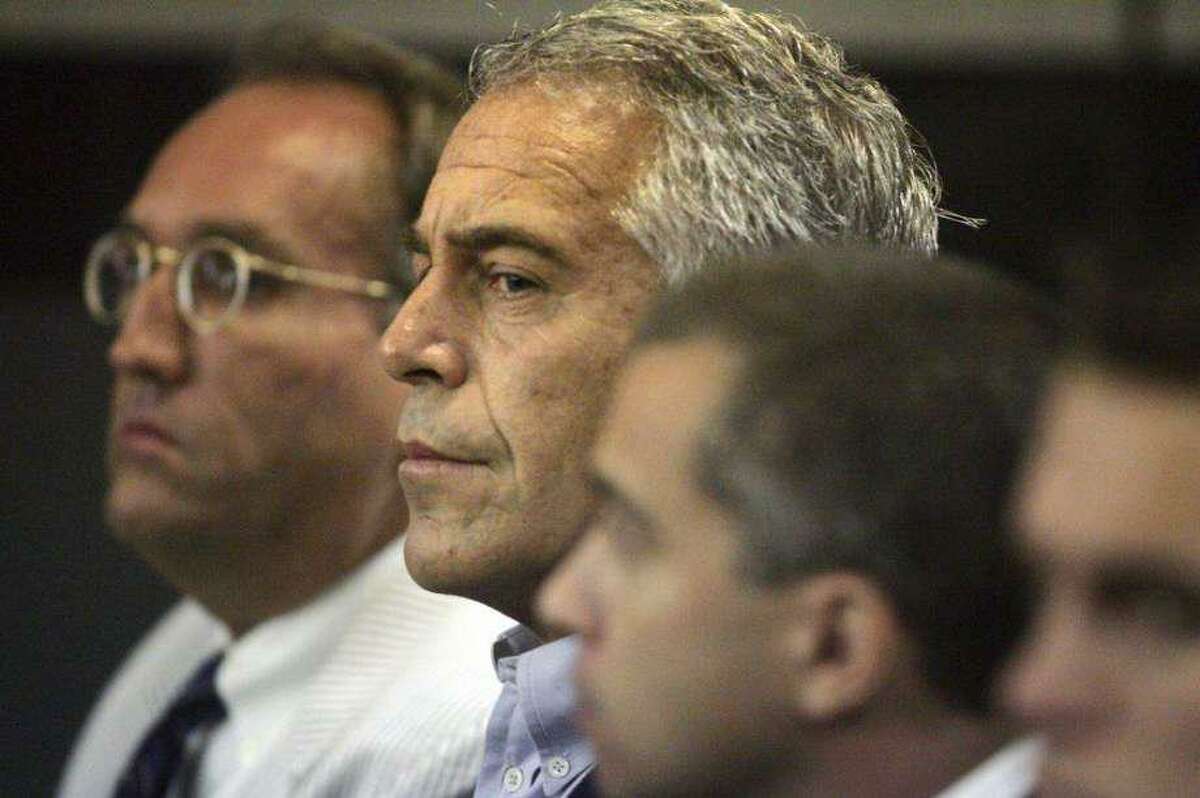 Financier and convicted sex offender Jeffrey Epstein, center, arrested in July on sex trafficking charges, is seen here in 2008 after he was taken into custody in Florida.